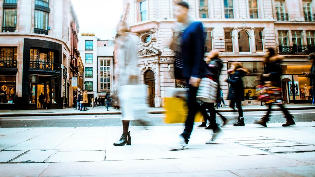 personas en movimiento con bolsas de compras