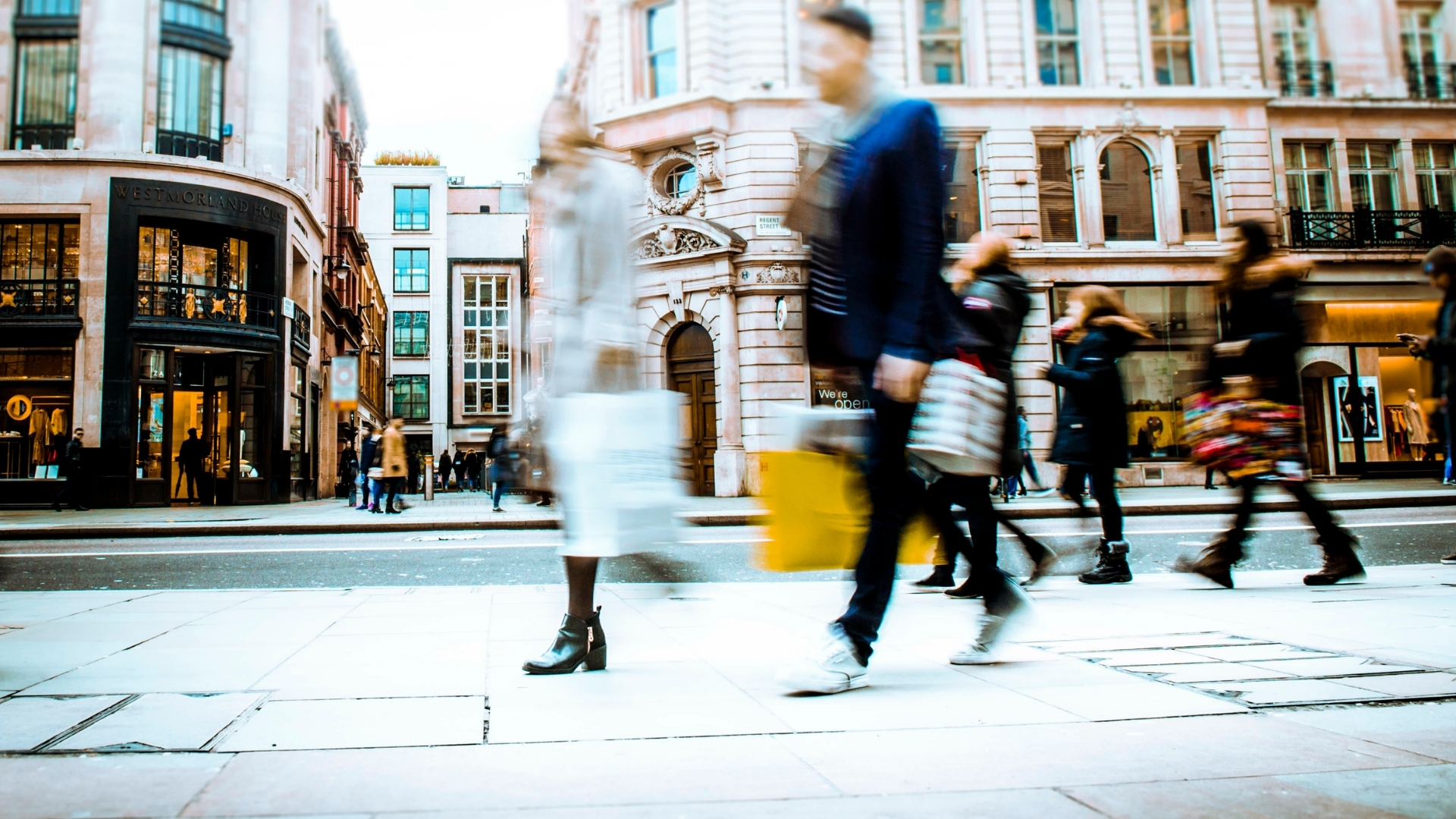 personas en movimiento con bolsas de compras