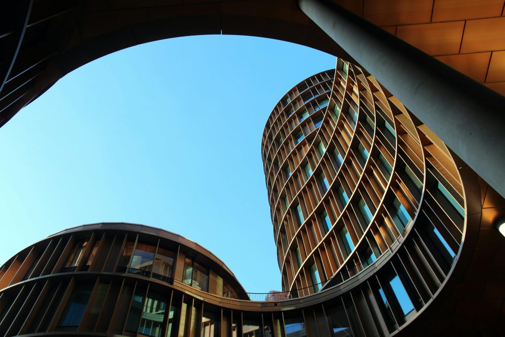 Innovative modern architecture showcasing curved glass structures against a clear blue sky.